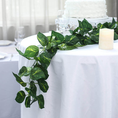 Artificial greenery garland for table decor with soft lighting and cake