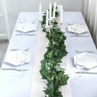 Elegant table setting with ivy runner and candles. Perfect for dining occasions.