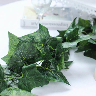Artificial ivy garland with realistic green leaves on a table.