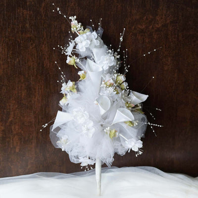 White floral wedding bouquet with lace and ribbons on a dark background.