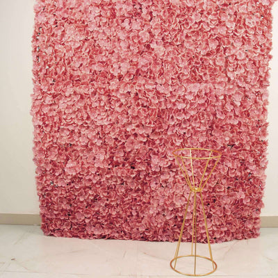 Pink floral backdrop with a gold geometric stand in front.