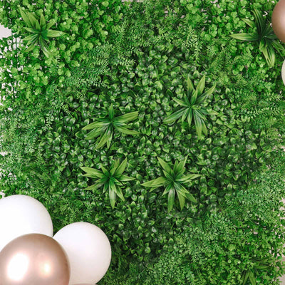 Artificial green foliage with decorative balloons for event styling.
