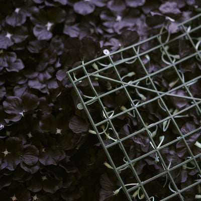Green wire grid resting on dark purple flower petals.