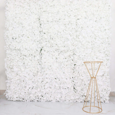 Gold metal plant stand against a white flower wall backdrop.