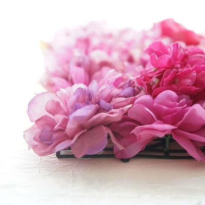 Pink silk flowers arranged on a black base.