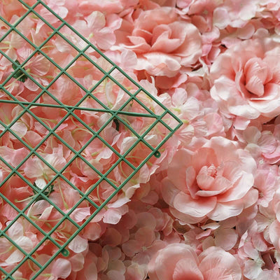 Green grid on pink floral background with artificial flowers.