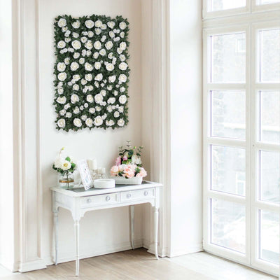 Decorative flower wall art above a white table with floral arrangements.