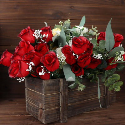 Artificial red roses arrangement in a rustic wooden box.