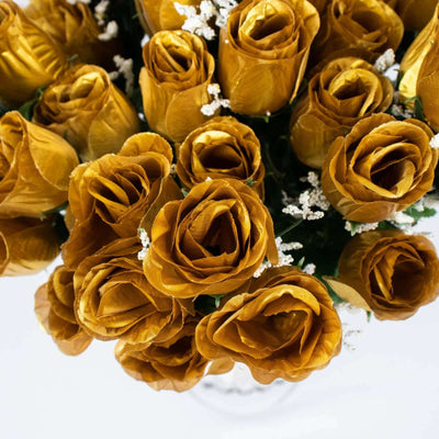 Bouquet of golden fabric roses with white accents on a plain background.