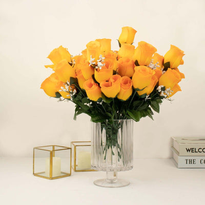 Bouquet of yellow roses in a clear glass vase with decorative accents.