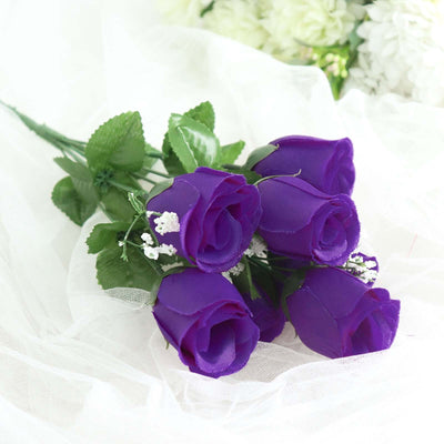 Purple artificial roses bouquet with greenery accents.