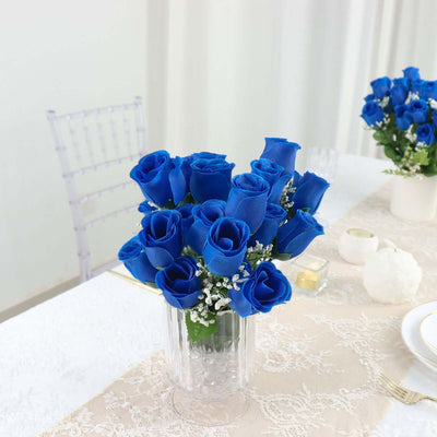 Blue roses bouquet in a glass vase on a decorated table.