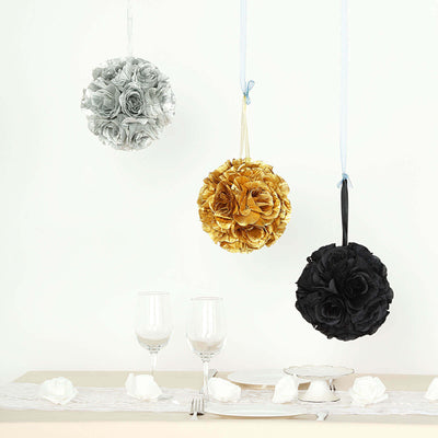 Hanging decorative flower balls in silver, gold, and black against a white backdrop