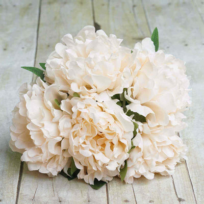 Cream peony bouquet on rustic wooden background.