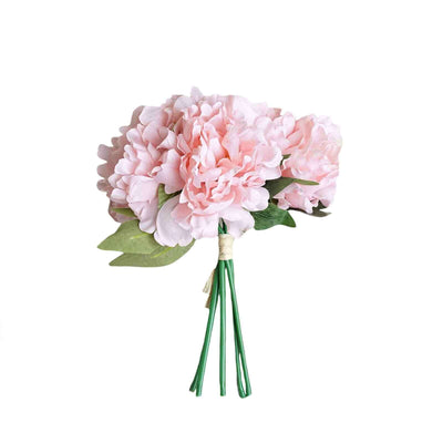 Pink artificial flower bouquet with green leaves on a white background.
