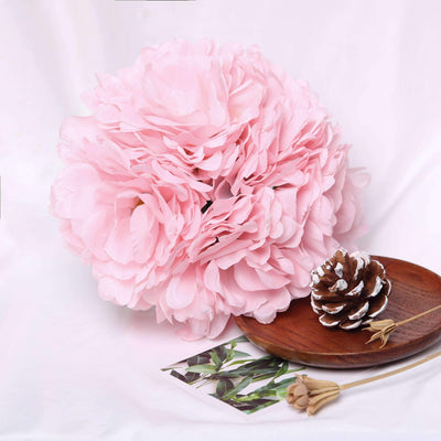 Pink floral arrangement with pinecone and decorative plate