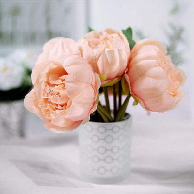 Peach artificial peony flowers in a white geometric vase