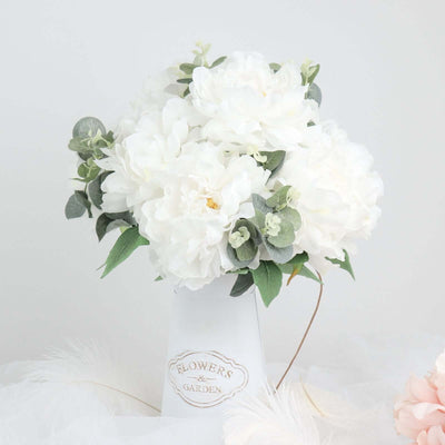 White peony bouquet in a white vase against a light backdrop