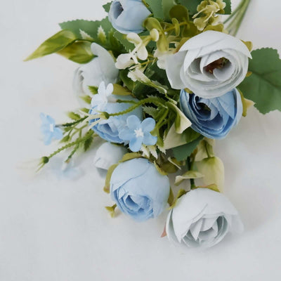 Blue paper flower bouquet with green leaves on white background.