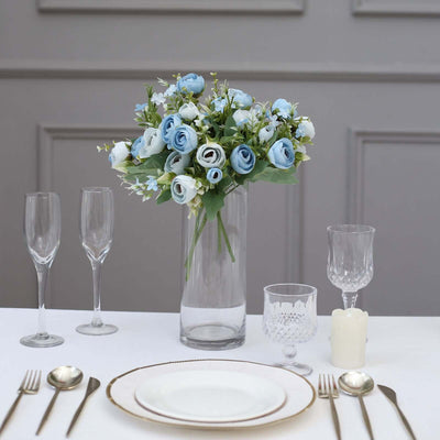 Blue rose bouquet centerpiece on a dining table with elegant tableware.