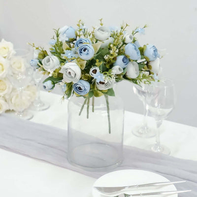 Blue and white floral arrangement in a clear vase on a dining table.