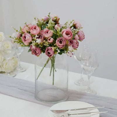 Pink rose bouquet in a glass vase on a table setting.