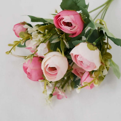 Pink and white artificial roses bouquet with greenery.