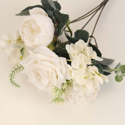 White artificial flower bouquet with roses and greenery
