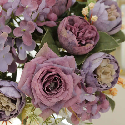Purple and lavender artificial flowers arranged in a bouquet.