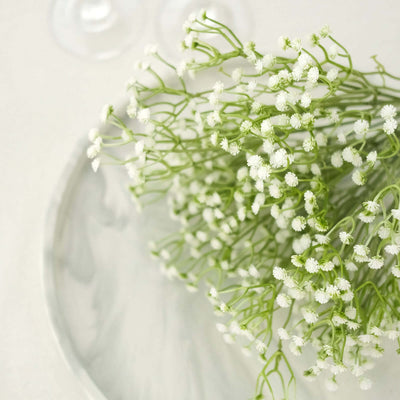 Delicate white flowers arranged on a marble plate.