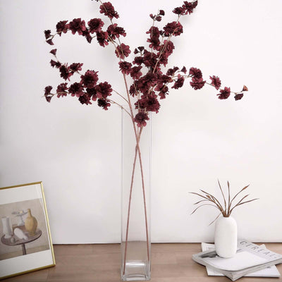 Tall glass vase with dried burgundy flowers, minimalist decor