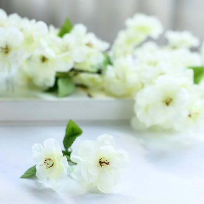 White floral arrangement with delicate blossoms and green leaves.