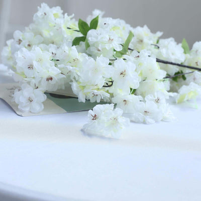 White cherry blossom flowers arranged elegantly on a table.
