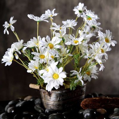White daisy flower arrangement in a rustic metal pot.