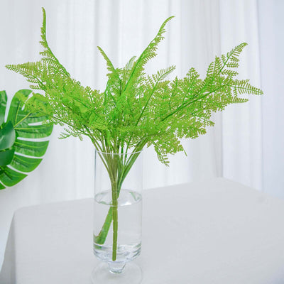 Vibrant green faux fern arrangement in a glass vase