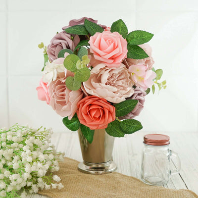 Artificial flower bouquet in a silver vase with greenery.