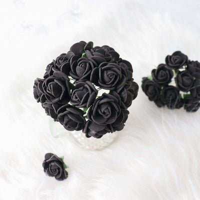 Black artificial rose bouquet in a glass vase on a soft white background.