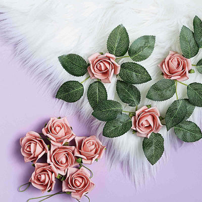 Pink artificial roses with green leaves on a fluffy white background.