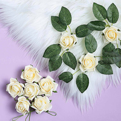 Artificial white roses with green leaves on a lavender background.