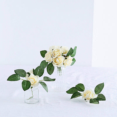 White roses in glass vases with greenery