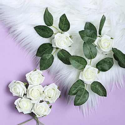 Artificial white roses with green leaves on a pastel purple background.