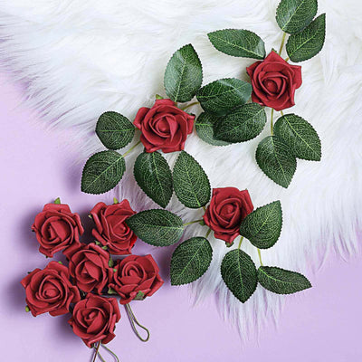 Red rose decorations with green leaves on a soft purple background.