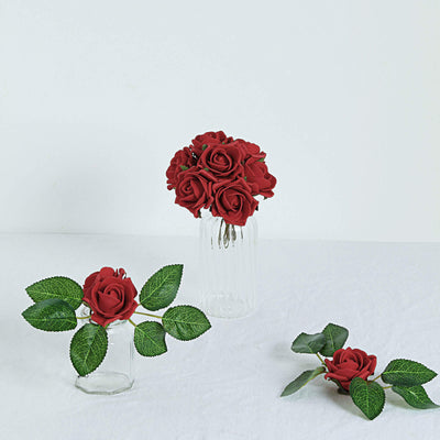 Red rose bouquet in glass vases with green leaves