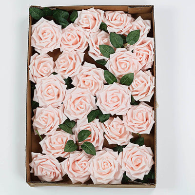 Pink artificial roses in a cardboard box with green leaves.