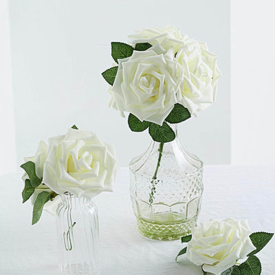 Artificial white roses in decorative glass vases.