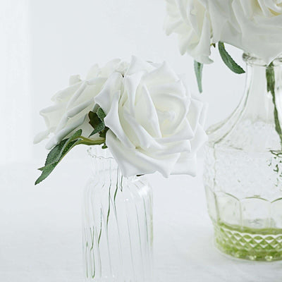 White rose arrangement in a glass vase on a light background.
