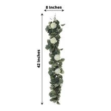 Floral garland with white flowers and green leaves made of eucalyptus leaves and ranunculus flowers