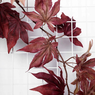 Red maple leaf garland on a grid background.