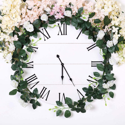 Floral wall clock with Roman numerals and greenery decoration