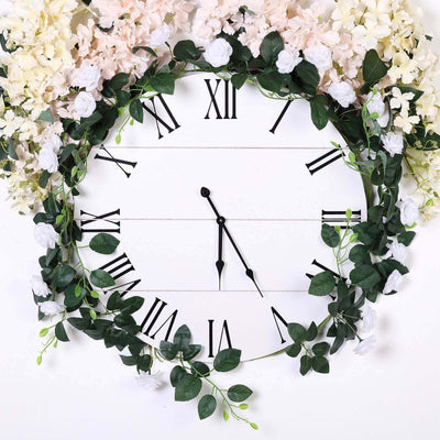 Floral wall clock with Roman numerals and greenery accents